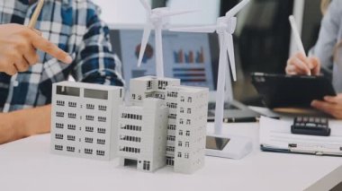 Mühendis model bir ev modeli tutuyor ve model bir ev modeli gösteriyor..