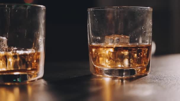 木桌上有冰块的威士忌杯 — 图库视频影像