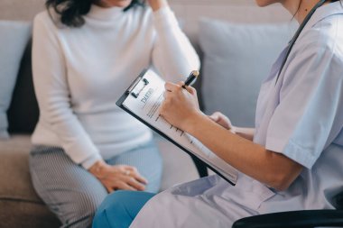 Asyalı doktor kadın, teşhis koymak ve evdeki ya da özel hastanedeki sağlığı kontrol etmek için hasta kadını ziyaret etti. Kadın hasta, sağlık sorununu ve belirtileri doktorlara açıklar.