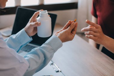 Asyalı doktor kadın, teşhis koymak ve evdeki ya da özel hastanedeki sağlığı kontrol etmek için hasta kadını ziyaret etti. Kadın hasta, sağlık sorununu ve belirtileri doktorlara açıklar.
