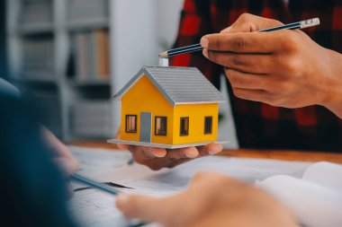 İnşaat mühendisi Asyalı 'nın ofis masasındaki inşaat sahasında mimari tasarım projesi üzerinde çalışmasını kapatın..