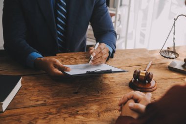 Adalet ve hukuk kavramı. Hukuk Müşaviri tokmak ve yasal hukuk veya yasal ile imzalanmış bir sözleşme istemciye sunar arka planda hukuk firmasında takım toplantısı