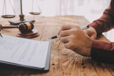 Adalet ve hukuk kavramı. Hukuk Müşaviri tokmak ve yasal hukuk veya yasal ile imzalanmış bir sözleşme istemciye sunar arka planda hukuk firmasında takım toplantısı