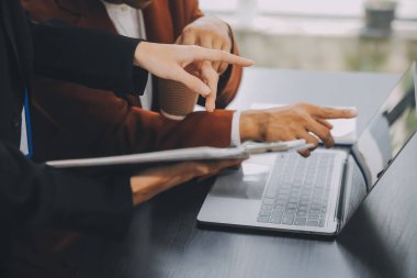 Finansal analistler, şirketlerin başarılı takım çalışmalarının sonuçlarını gösteren bir toplantıda bir dijital tablet planlama yatırım projesinin ticari mali raporlarını analiz ediyorlar..