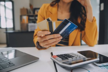 Evde kredi kartı tutan ve akıllı telefonlar kullanan kadınlar. Çevrimiçi alışveriş, internet bankacılığı, çevrimiçi mağaza, ödeme, harcama parası, e-ticaret ödemesi, kredi kartı, konsept