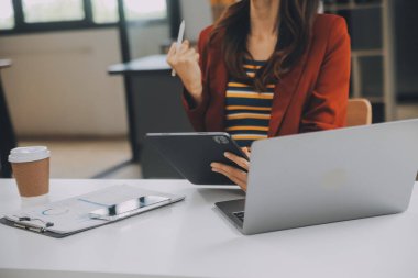 Kapalı alanda cep telefonu kullanan mutlu bir Asyalı iş kadınının portresi. Modern ofiste çalışan Asyalı bir iş kadını..