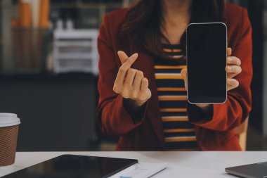 Kapalı alanda cep telefonu kullanan mutlu bir Asyalı iş kadınının portresi. Modern ofiste çalışan Asyalı bir iş kadını..