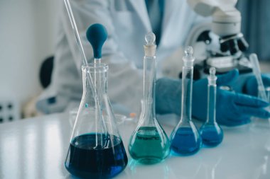 Coronavirus aşısı geliştirmek için mikroskop ile çalışan biyokimyasal araştırma ekibi farmasötik araştırma laboratuvarında, seçici odaklı