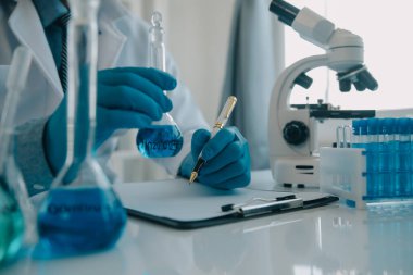 Coronavirus aşısı geliştirmek için mikroskop ile çalışan biyokimyasal araştırma ekibi farmasötik araştırma laboratuvarında, seçici odaklı