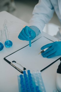 Coronavirus aşısı geliştirmek için mikroskop ile çalışan biyokimyasal araştırma ekibi farmasötik araştırma laboratuvarında, seçici odaklı