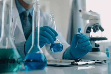 Coronavirus aşısı geliştirmek için mikroskop ile çalışan biyokimyasal araştırma ekibi farmasötik araştırma laboratuvarında, seçici odaklı