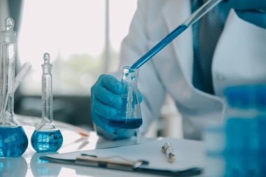 Coronavirus aşısı geliştirmek için mikroskop ile çalışan biyokimyasal araştırma ekibi farmasötik araştırma laboratuvarında, seçici odaklı