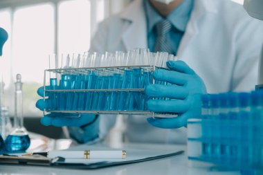 Coronavirus aşısı geliştirmek için mikroskop ile çalışan biyokimyasal araştırma ekibi farmasötik araştırma laboratuvarında, seçici odaklı