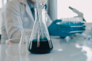 Coronavirus aşısı geliştirmek için mikroskop ile çalışan biyokimyasal araştırma ekibi farmasötik araştırma laboratuvarında, seçici odaklı