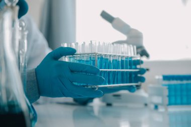 Coronavirus aşısı geliştirmek için mikroskop ile çalışan biyokimyasal araştırma ekibi farmasötik araştırma laboratuvarında, seçici odaklı