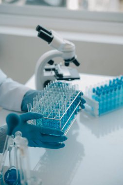 Coronavirus aşısı geliştirmek için mikroskop ile çalışan biyokimyasal araştırma ekibi farmasötik araştırma laboratuvarında, seçici odaklı
