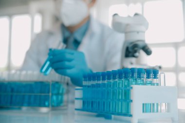 Coronavirus aşısı geliştirmek için mikroskop ile çalışan biyokimyasal araştırma ekibi farmasötik araştırma laboratuvarında, seçici odaklı