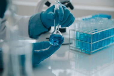 Coronavirus aşısı geliştirmek için mikroskop ile çalışan biyokimyasal araştırma ekibi farmasötik araştırma laboratuvarında, seçici odaklı