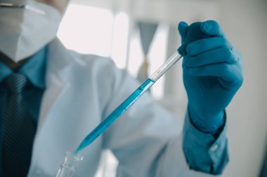 Coronavirus aşısı geliştirmek için mikroskop ile çalışan biyokimyasal araştırma ekibi farmasötik araştırma laboratuvarında, seçici odaklı