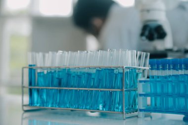 Coronavirus aşısı geliştirmek için mikroskop ile çalışan biyokimyasal araştırma ekibi farmasötik araştırma laboratuvarında, seçici odaklı