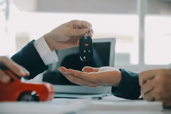 Closeup asian male people car salesman or sales manager offers to sell a car and explains and reads the terms of signing a car contract and insurance.