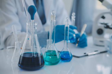 Coronavirus aşısı geliştirmek için mikroskop ile çalışan biyokimyasal araştırma ekibi farmasötik araştırma laboratuvarında, seçici odaklı