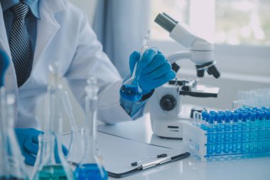 Coronavirus aşısı geliştirmek için mikroskop ile çalışan biyokimyasal araştırma ekibi farmasötik araştırma laboratuvarında, seçici odaklı