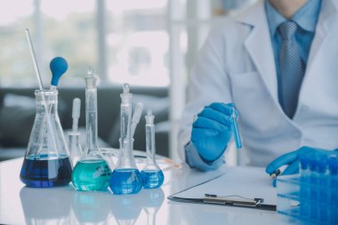 Coronavirus aşısı geliştirmek için mikroskop ile çalışan biyokimyasal araştırma ekibi farmasötik araştırma laboratuvarında, seçici odaklı