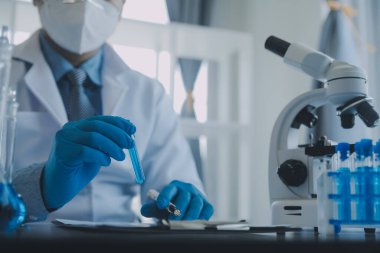 Coronavirus aşısı geliştirmek için mikroskop ile çalışan biyokimyasal araştırma ekibi farmasötik araştırma laboratuvarında, seçici odaklı