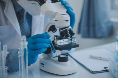 Coronavirus aşısı geliştirmek için mikroskop ile çalışan biyokimyasal araştırma ekibi farmasötik araştırma laboratuvarında, seçici odaklı