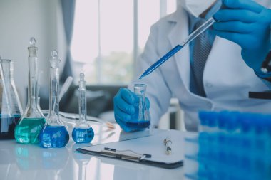 Coronavirus aşısı geliştirmek için mikroskop ile çalışan biyokimyasal araştırma ekibi farmasötik araştırma laboratuvarında, seçici odaklı