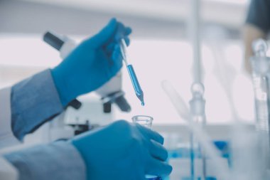 Coronavirus aşısı geliştirmek için mikroskop ile çalışan biyokimyasal araştırma ekibi farmasötik araştırma laboratuvarında, seçici odaklı