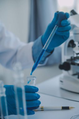 Coronavirus aşısı geliştirmek için mikroskop ile çalışan biyokimyasal araştırma ekibi farmasötik araştırma laboratuvarında, seçici odaklı