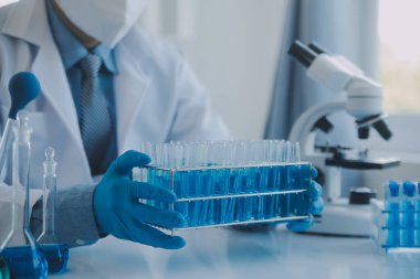 Coronavirus aşısı geliştirmek için mikroskop ile çalışan biyokimyasal araştırma ekibi farmasötik araştırma laboratuvarında, seçici odaklı
