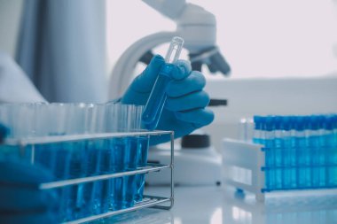 Coronavirus aşısı geliştirmek için mikroskop ile çalışan biyokimyasal araştırma ekibi farmasötik araştırma laboratuvarında, seçici odaklı