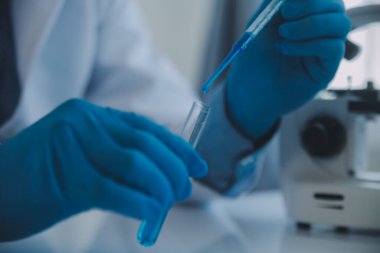 Coronavirus aşısı geliştirmek için mikroskop ile çalışan biyokimyasal araştırma ekibi farmasötik araştırma laboratuvarında, seçici odaklı