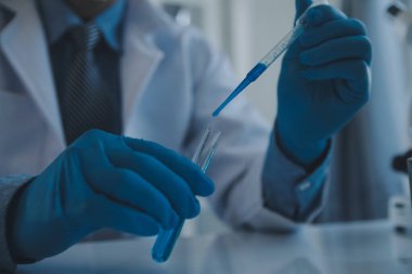 Coronavirus aşısı geliştirmek için mikroskop ile çalışan biyokimyasal araştırma ekibi farmasötik araştırma laboratuvarında, seçici odaklı