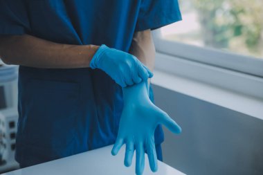 Doktor ya da hemşire mavi nitril cerrahi eldiven, profesyonel tıbbi güvenlik ve beyaz arka plan için hijyen ve sağlık muayenesi yapıyor..