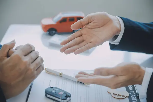 Kapalı Asyalı erkek araba satıcısı ya da satış müdürü bir araba satmayı teklif ediyor ve bir araba sözleşmesi ve sigorta sözleşmesi imzalama şartlarını açıklıyor..