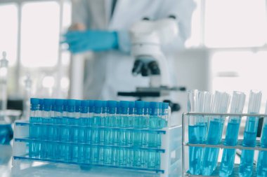 Coronavirus aşısı geliştirmek için mikroskop ile çalışan biyokimyasal araştırma ekibi farmasötik araştırma laboratuvarında, seçici odaklı