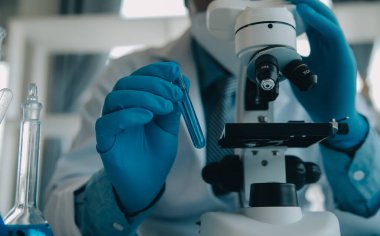 Coronavirus aşısı geliştirmek için mikroskop ile çalışan biyokimyasal araştırma ekibi farmasötik araştırma laboratuvarında, seçici odaklı