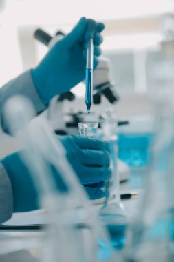 Coronavirus aşısı geliştirmek için mikroskop ile çalışan biyokimyasal araştırma ekibi farmasötik araştırma laboratuvarında, seçici odaklı