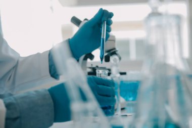 Coronavirus aşısı geliştirmek için mikroskop ile çalışan biyokimyasal araştırma ekibi farmasötik araştırma laboratuvarında, seçici odaklı