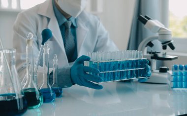 Coronavirus aşısı geliştirmek için mikroskop ile çalışan biyokimyasal araştırma ekibi farmasötik araştırma laboratuvarında, seçici odaklı