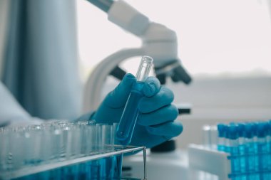 Coronavirus aşısı geliştirmek için mikroskop ile çalışan biyokimyasal araştırma ekibi farmasötik araştırma laboratuvarında, seçici odaklı