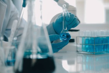 Coronavirus aşısı geliştirmek için mikroskop ile çalışan biyokimyasal araştırma ekibi farmasötik araştırma laboratuvarında, seçici odaklı