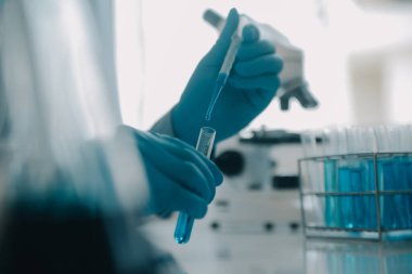 Coronavirus aşısı geliştirmek için mikroskop ile çalışan biyokimyasal araştırma ekibi farmasötik araştırma laboratuvarında, seçici odaklı