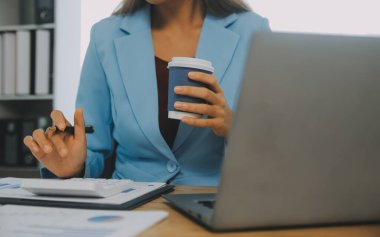 İş ekibi ile yeni başlangıç planı ve tartışma için proje bilgilerini dizüstü bilgisayar ve dijital tablet ile mali strateji bir modern iş salonda çalışıyor.