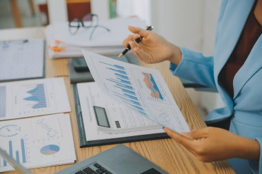 İş ekibi ile yeni başlangıç planı ve tartışma için proje bilgilerini dizüstü bilgisayar ve dijital tablet ile mali strateji bir modern iş salonda çalışıyor.