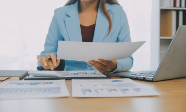 İş ekibi ile yeni başlangıç planı ve tartışma için proje bilgilerini dizüstü bilgisayar ve dijital tablet ile mali strateji bir modern iş salonda çalışıyor.